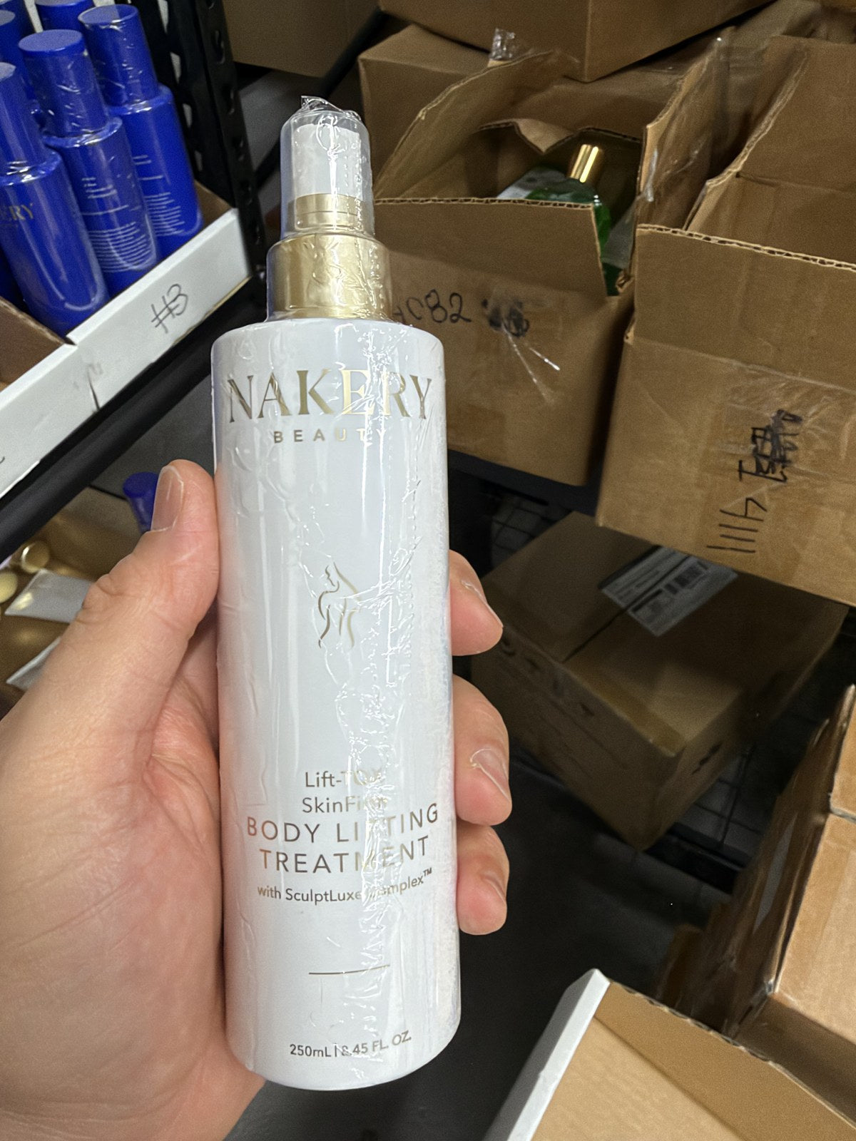 Nakery Beauty Lift-TOX SkinFirm Body Lifting Treatment 250 mL spray bottle in hand