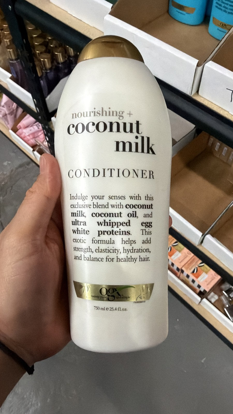 OGX Coconut Milk Conditioner in hand, second view